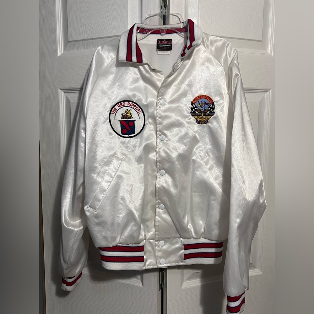 White Hilton Active Apparel nylon jacket with red and blue stripes.